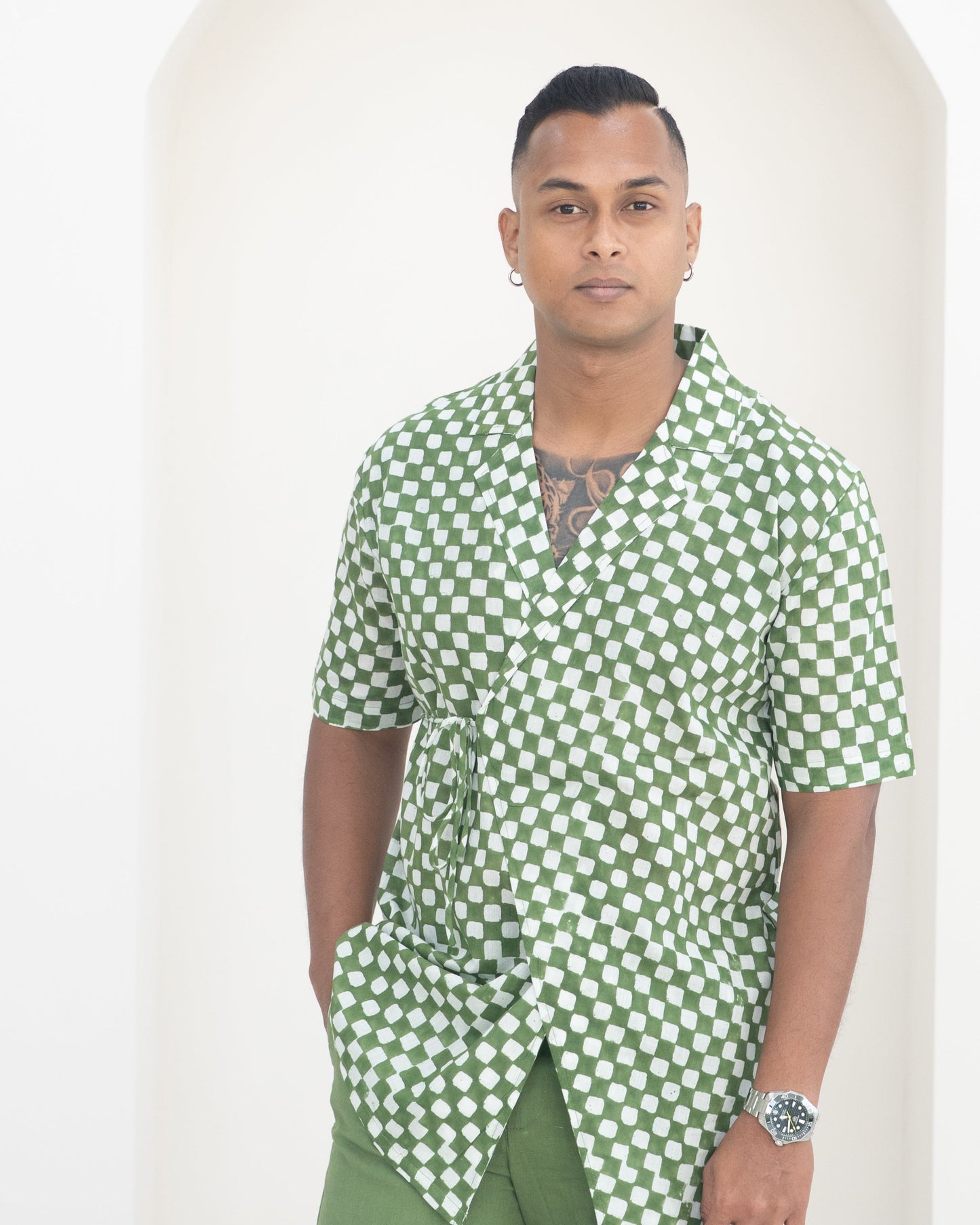 Man wearing a green and white checkered shirt against a plain background