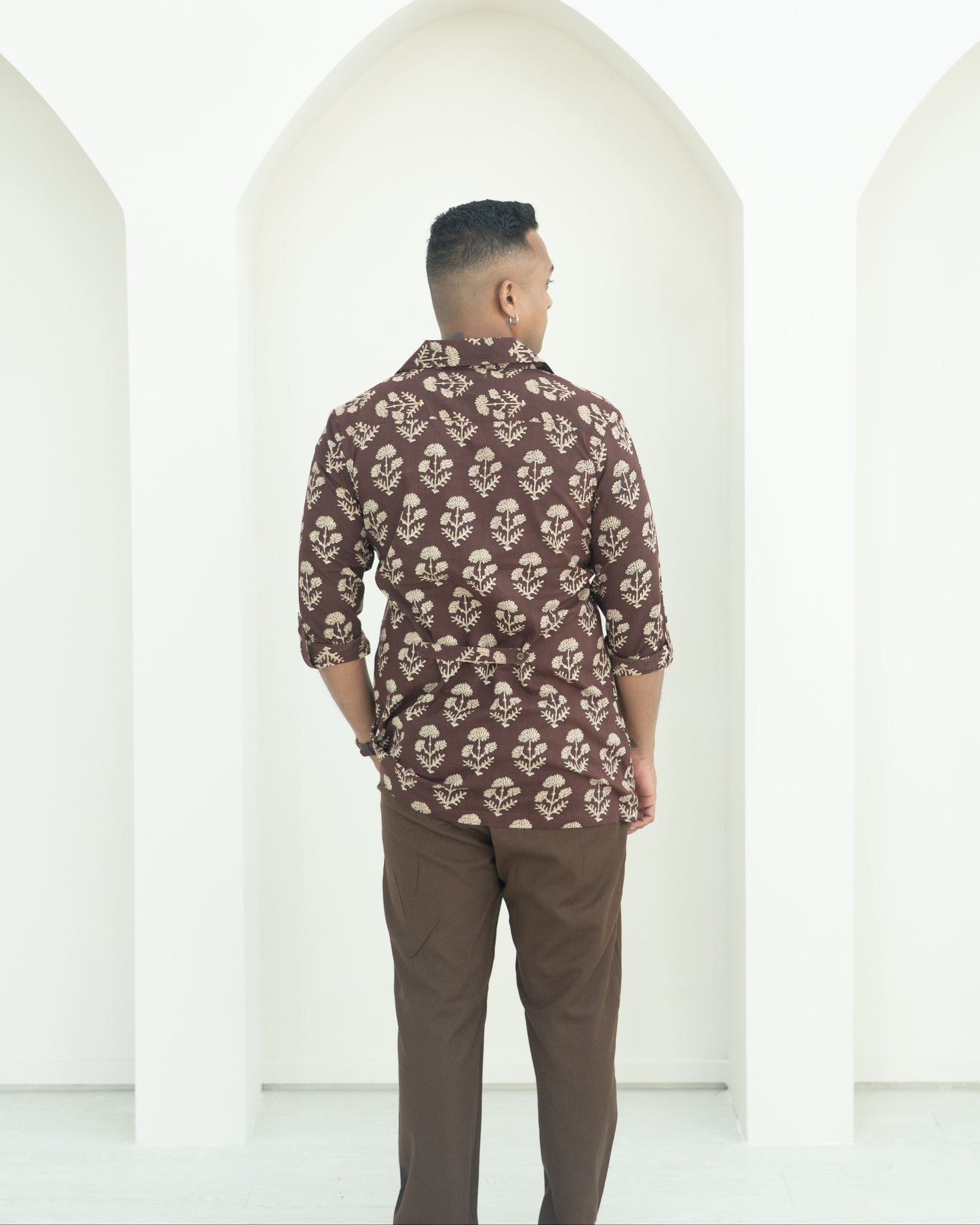 Man wearing a patterned shirt and brown pants