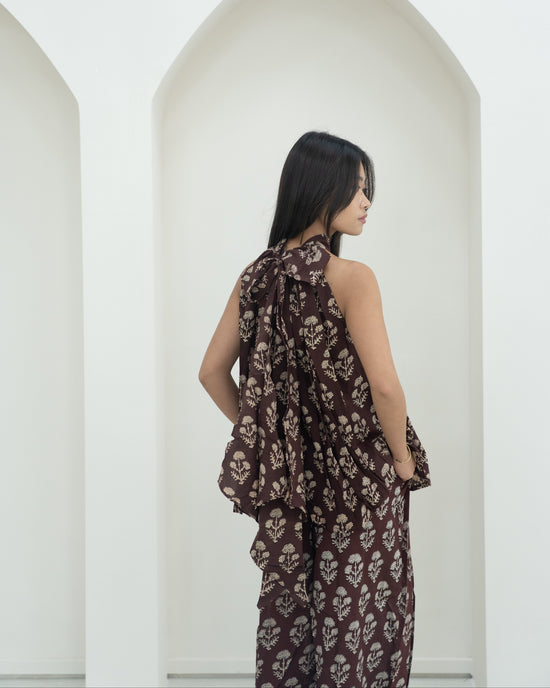 Woman wearing a floral outfit standing against a white background