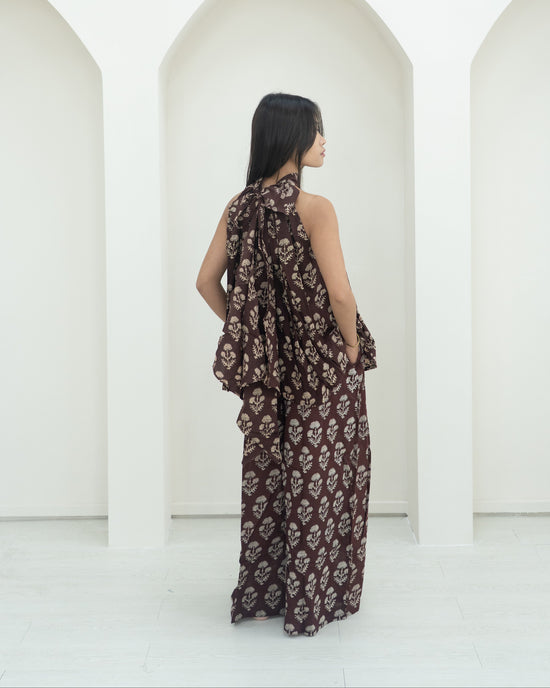 Woman in a floral outfit standing in front of white arches