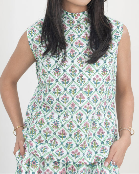 Woman wearing a sleeveless floral co-ord against a white background