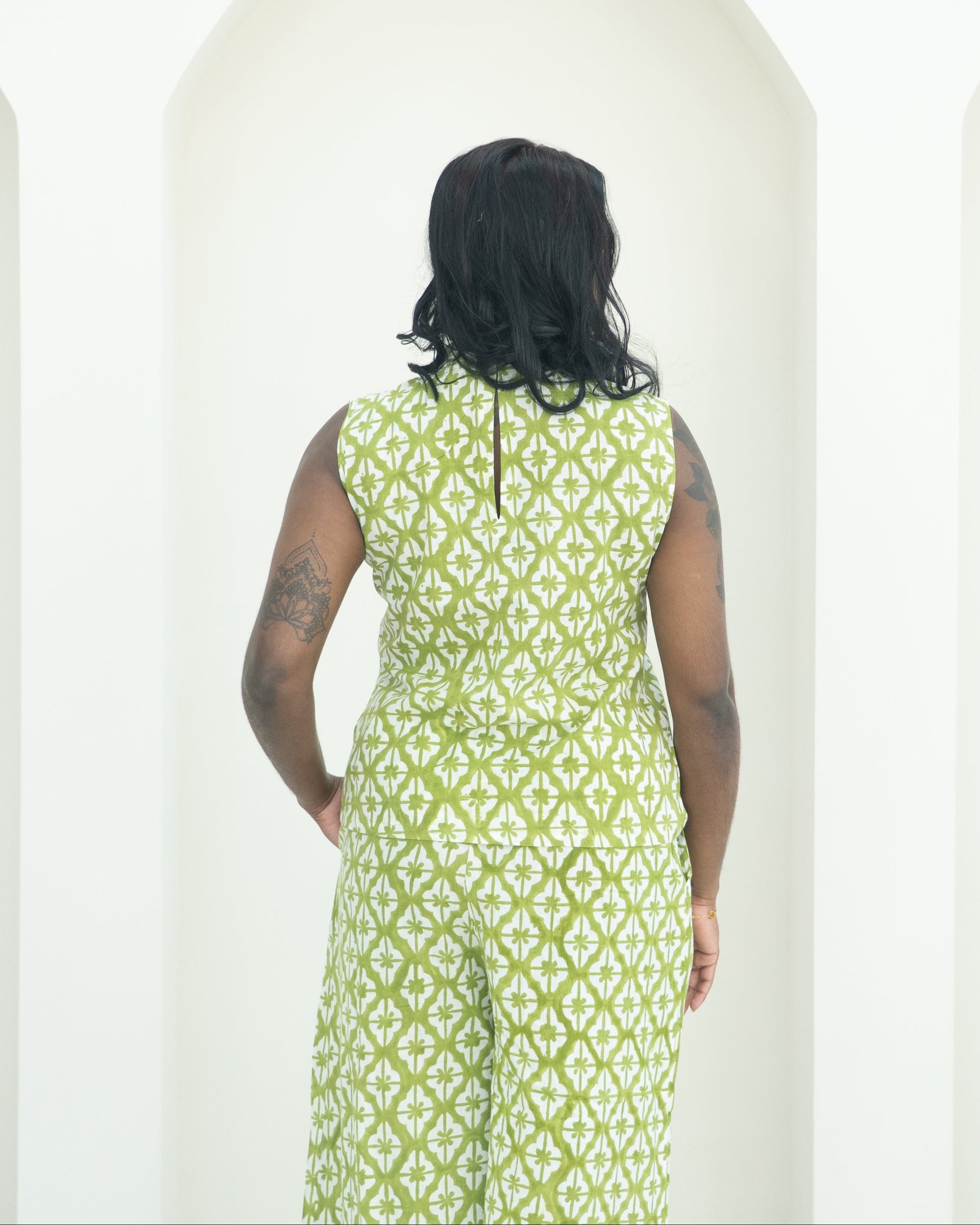 Person wearing a green patterned co-ord standing against a white background