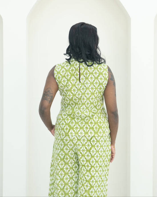 Person wearing a green patterned co-ord standing against a white background
