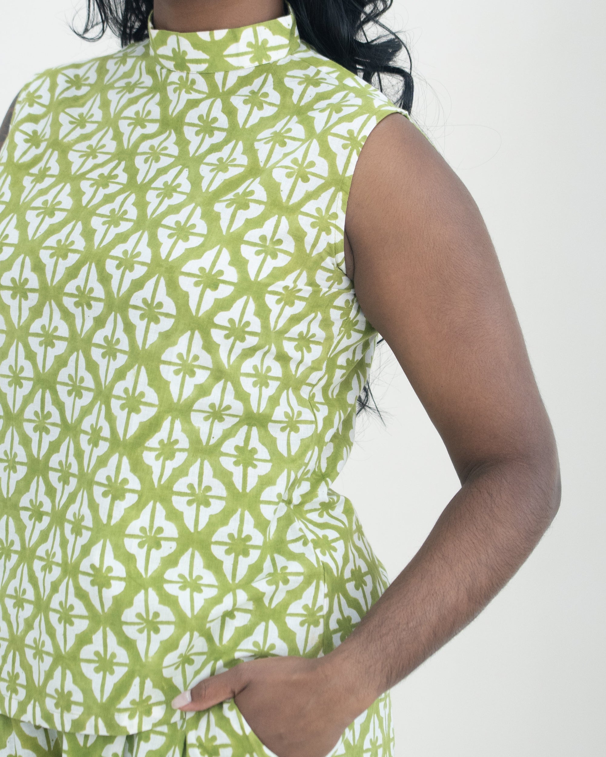 Woman wearing a green and white patterned sleeveless co-ord against a white background