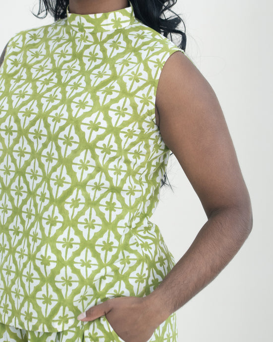 Woman wearing a green and white patterned sleeveless co-ord against a white background
