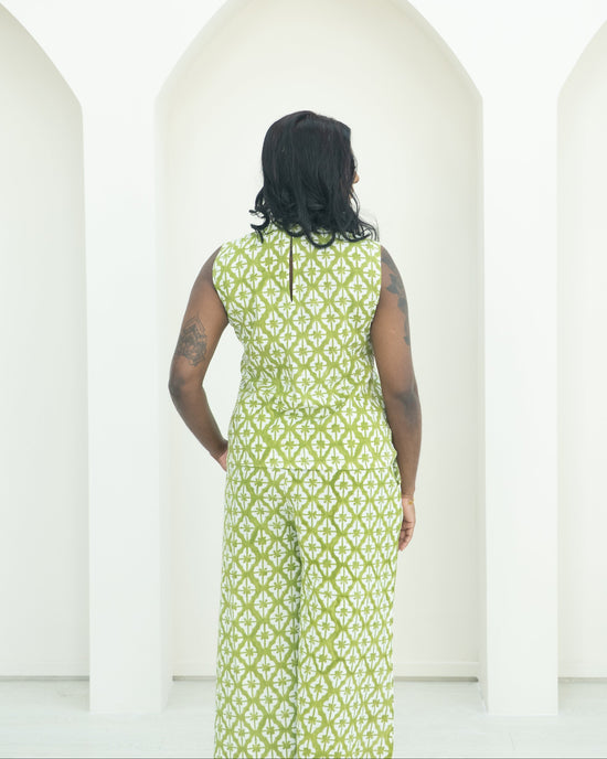 Person wearing a green patterned co-ord set standing against a white background.