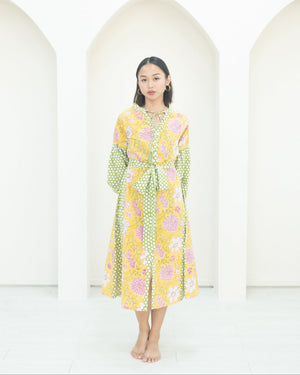 Woman wearing a floral dress standing against a white background