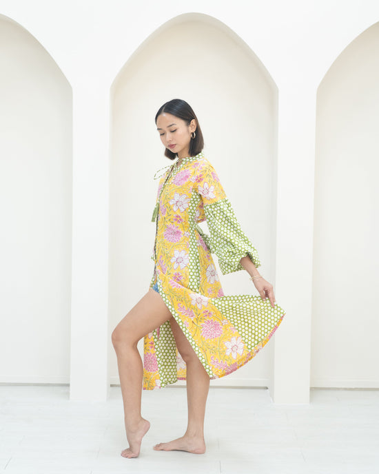 Woman wearing a colorful floral dress against a white background