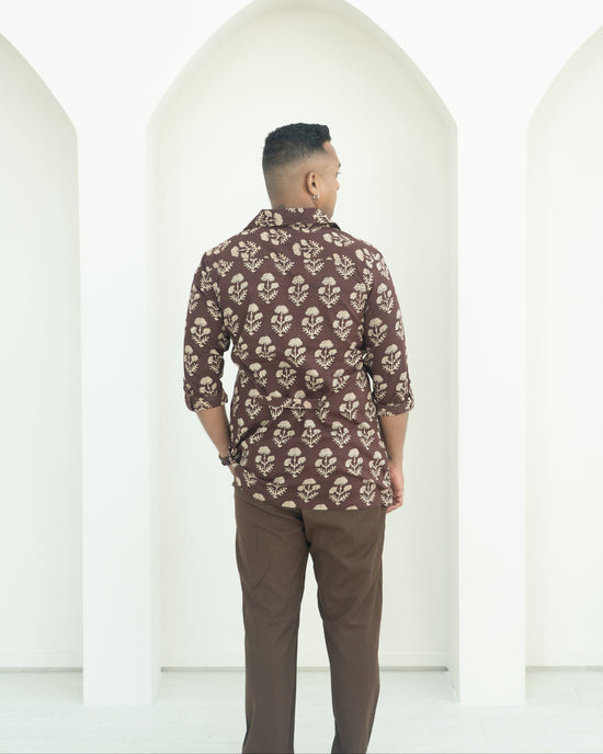 Man wearing a patterned shirt and brown pants